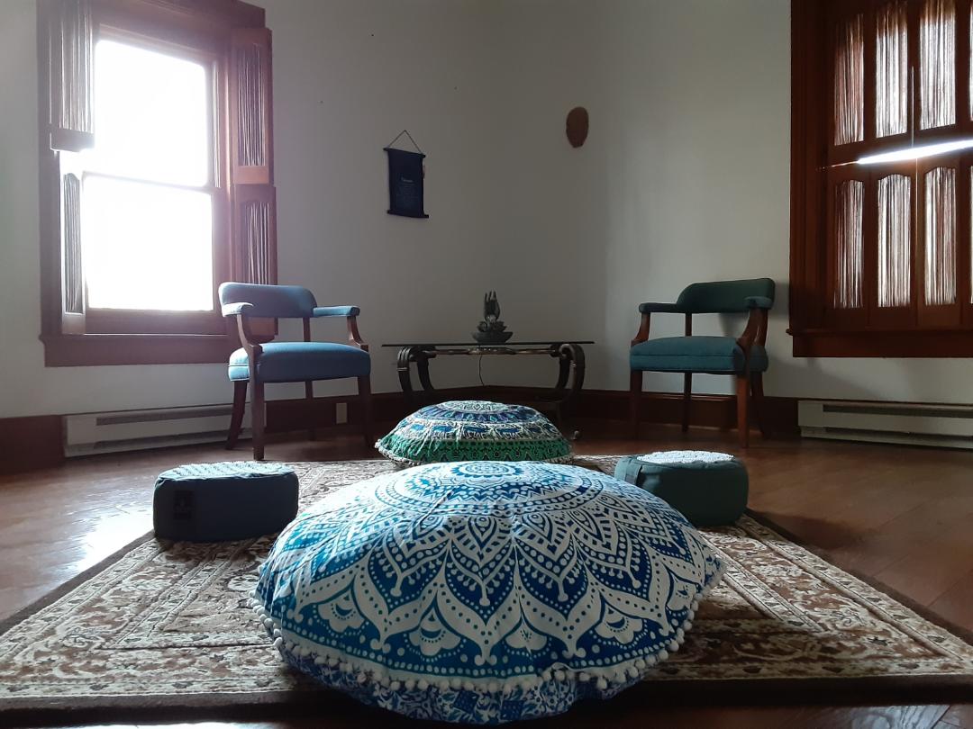 A few comfortable pillows are on the floor with a table and two chairs in the background.