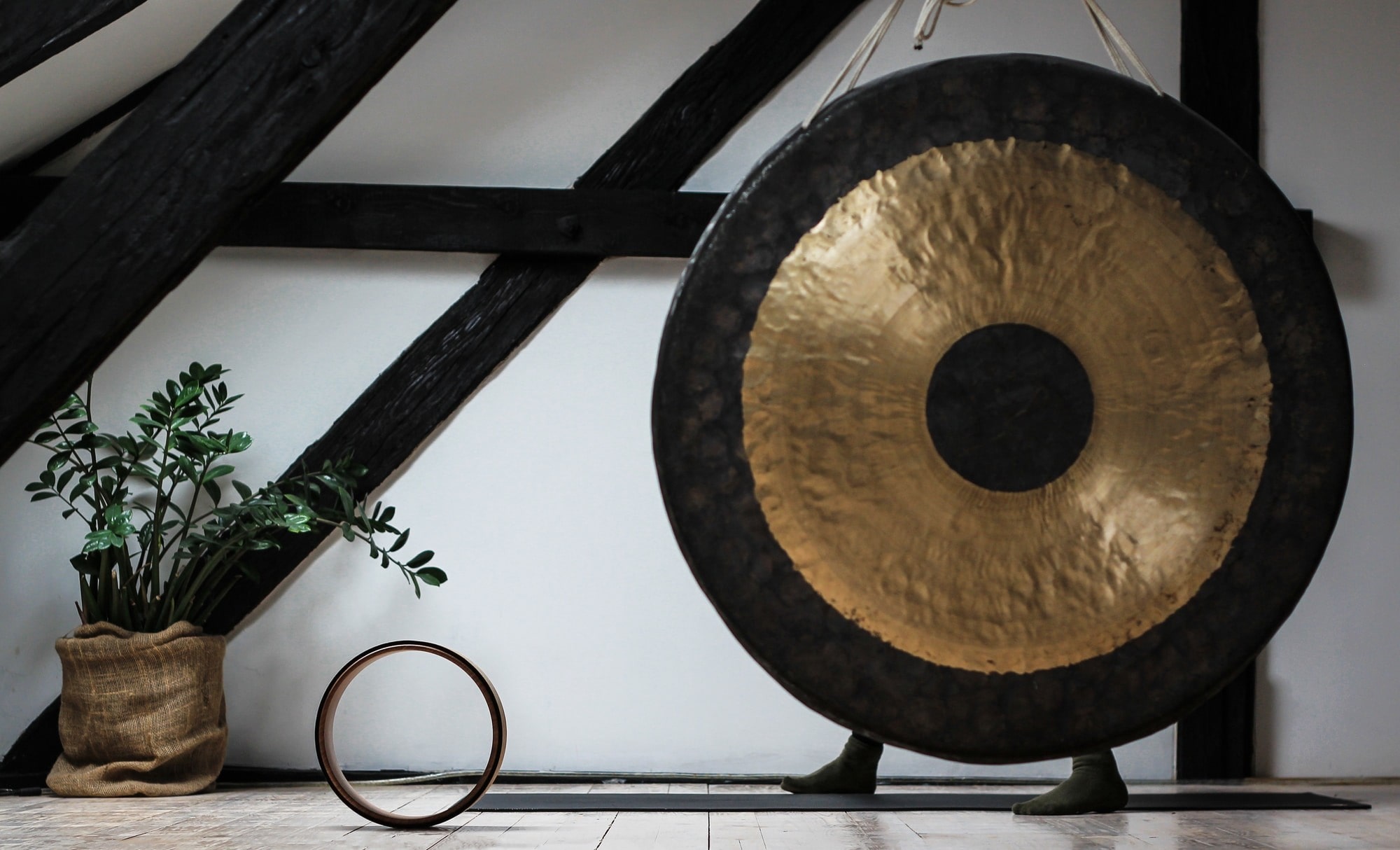 A gong is place in a tranquil spot representing the effects that come from a sound healing session.