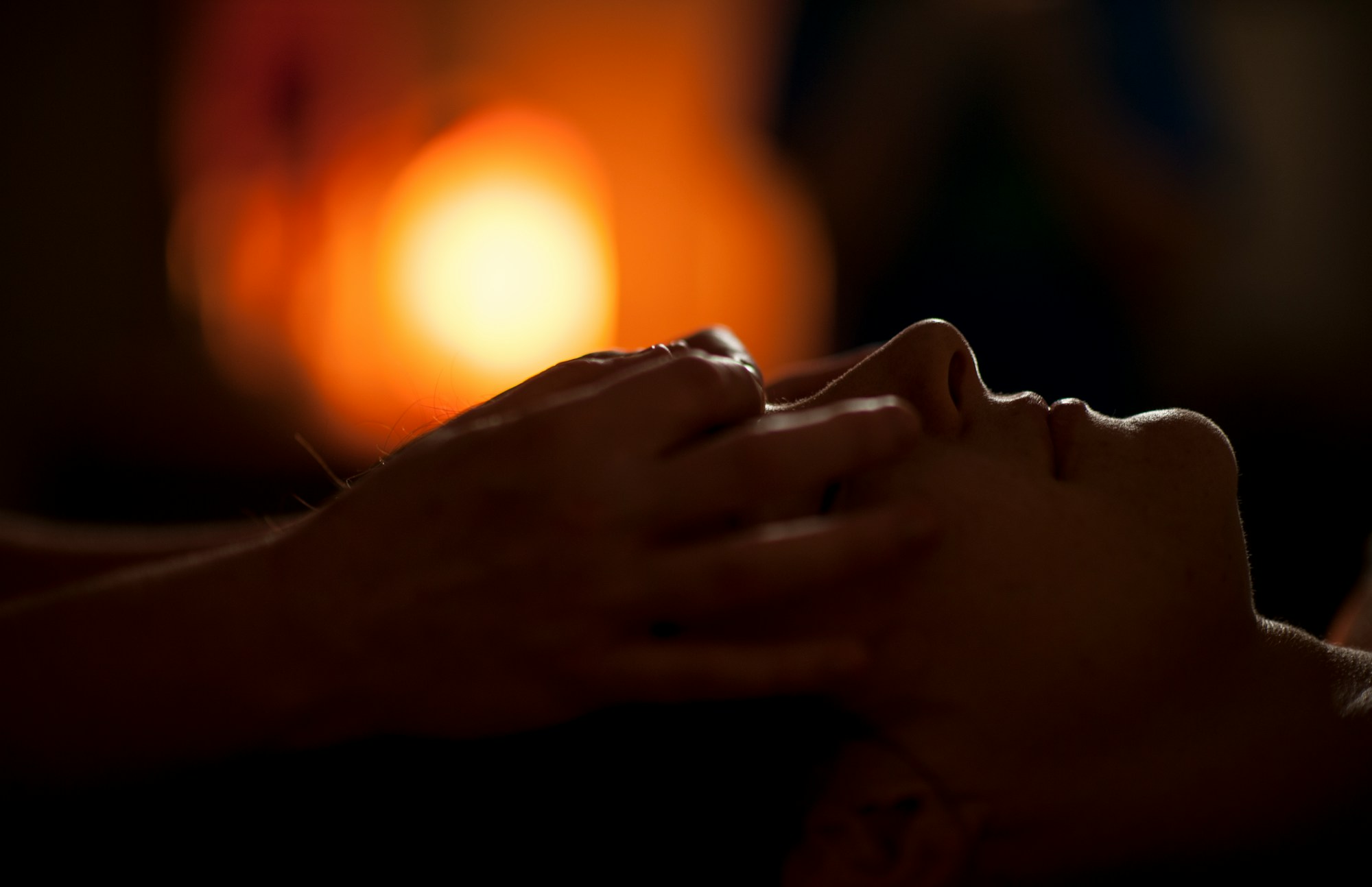 A Reiki practitioner has their hands on a clients head allowing the healing Reiki energy to flow for their greatest good.
